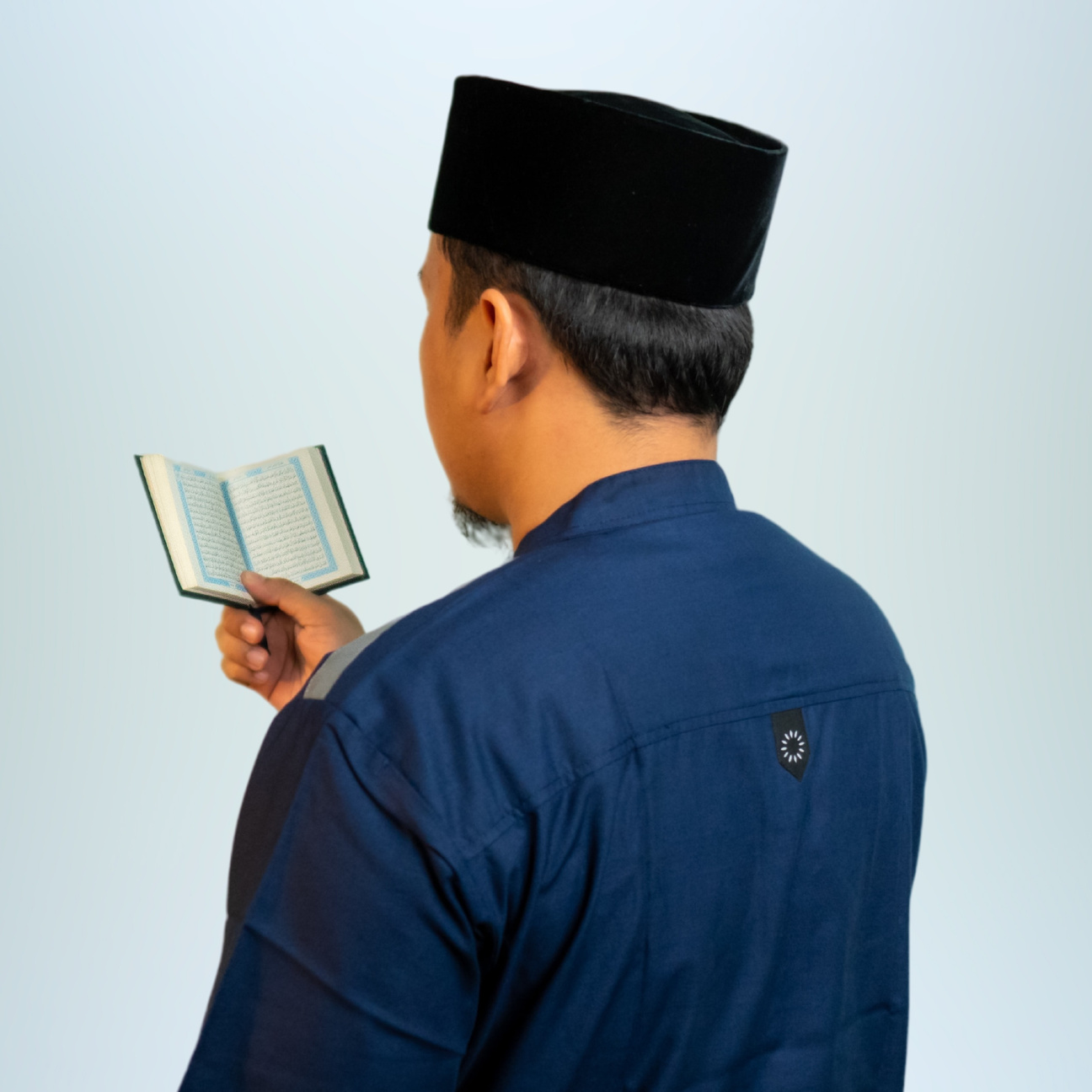a Muslim man reading the Al Qur'an